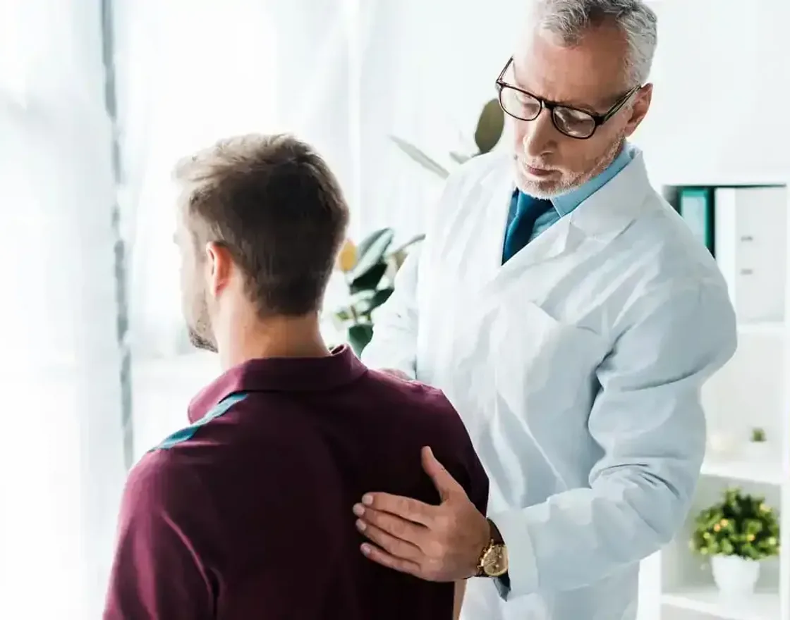 A chiropractor evaluating a patient's back during an examination in Tampa