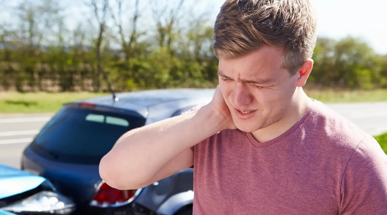 A patient holding his neck after a car accident before rehabilitation in Tampa