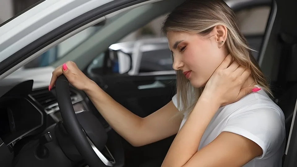 A driver noticing delayed neck pain after a car accident
