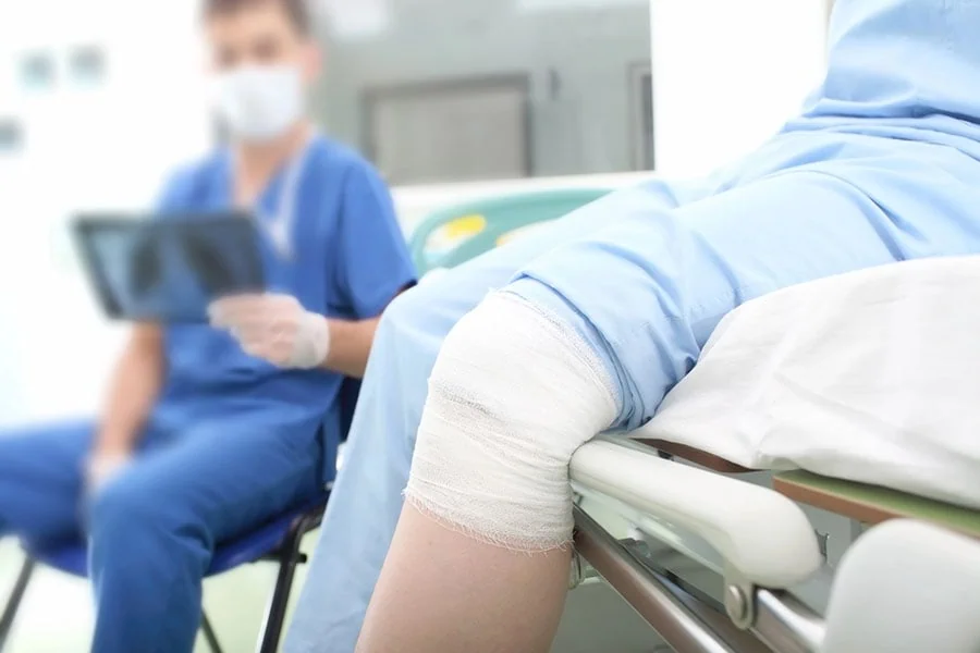 A clinician evaluating a bandaged leg during an urgent care visit