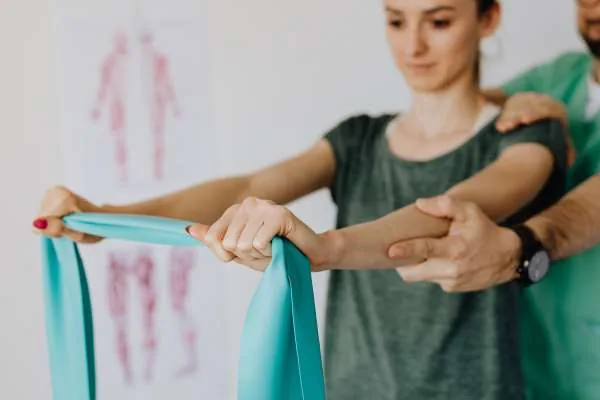 Therapist guiding a patient through a therapeutic exercise with a resistance band in Tampa